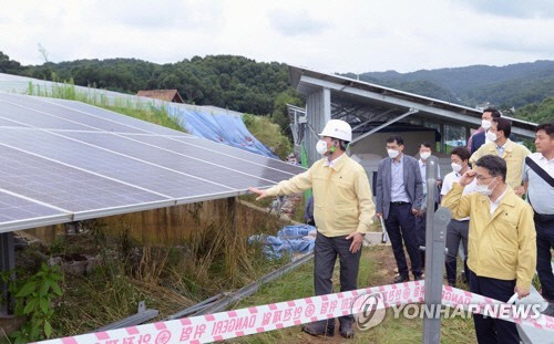 지난해 8월 성윤모 산업통상자원부 장관(왼쪽)이 집중호우로 피해를 본 충남 천안시 목천읍 소재 드림천안에너지를 방문, 태양광발전 설비를 살펴보고 있다. <산업통상자원부 제공>